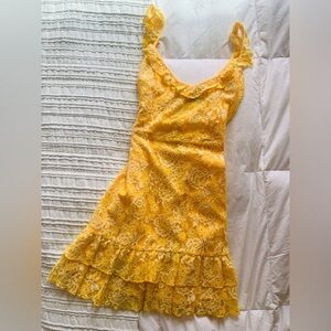 Flirty bright marigold cocktail dress with curly straps and flounce